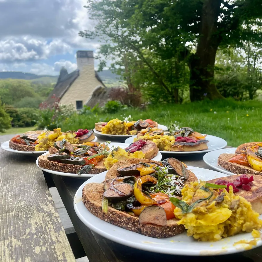 Fresh outdoor breakfasts with the thatched cottage behind